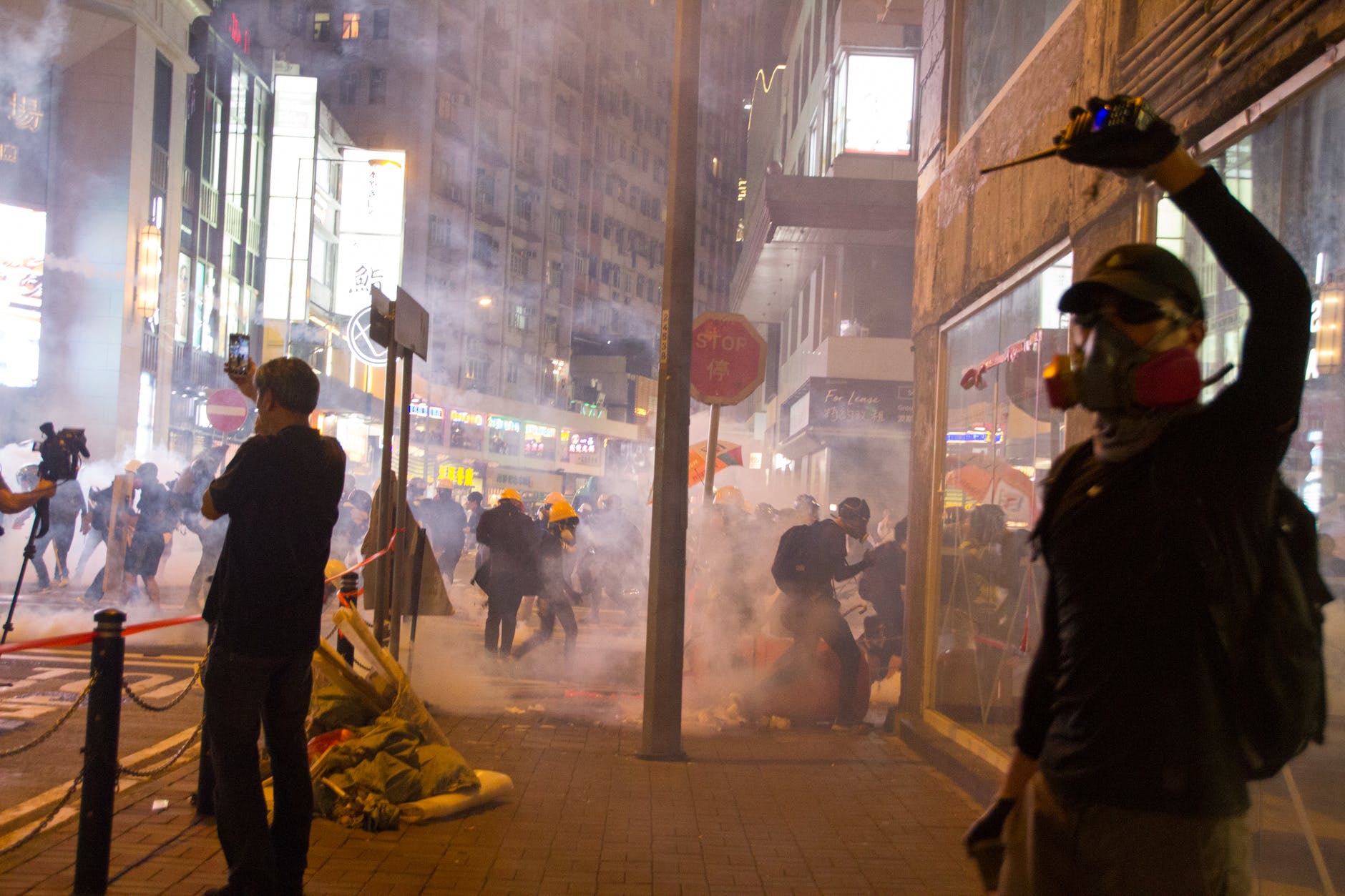 man wearing gas mask standing beside store facade